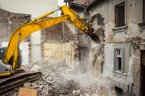 Excavator demolishing a building.